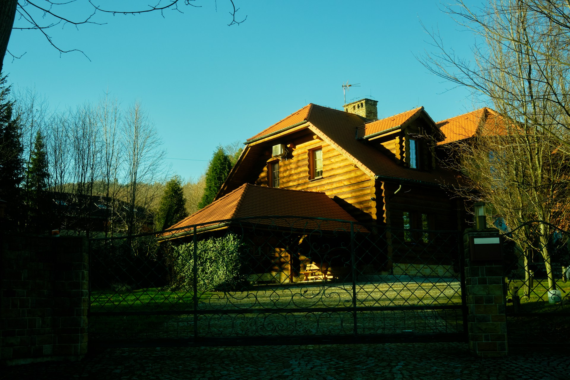 a large wooden house with a gate in front of it