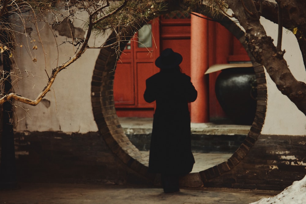 a person standing in front of a circular mirror