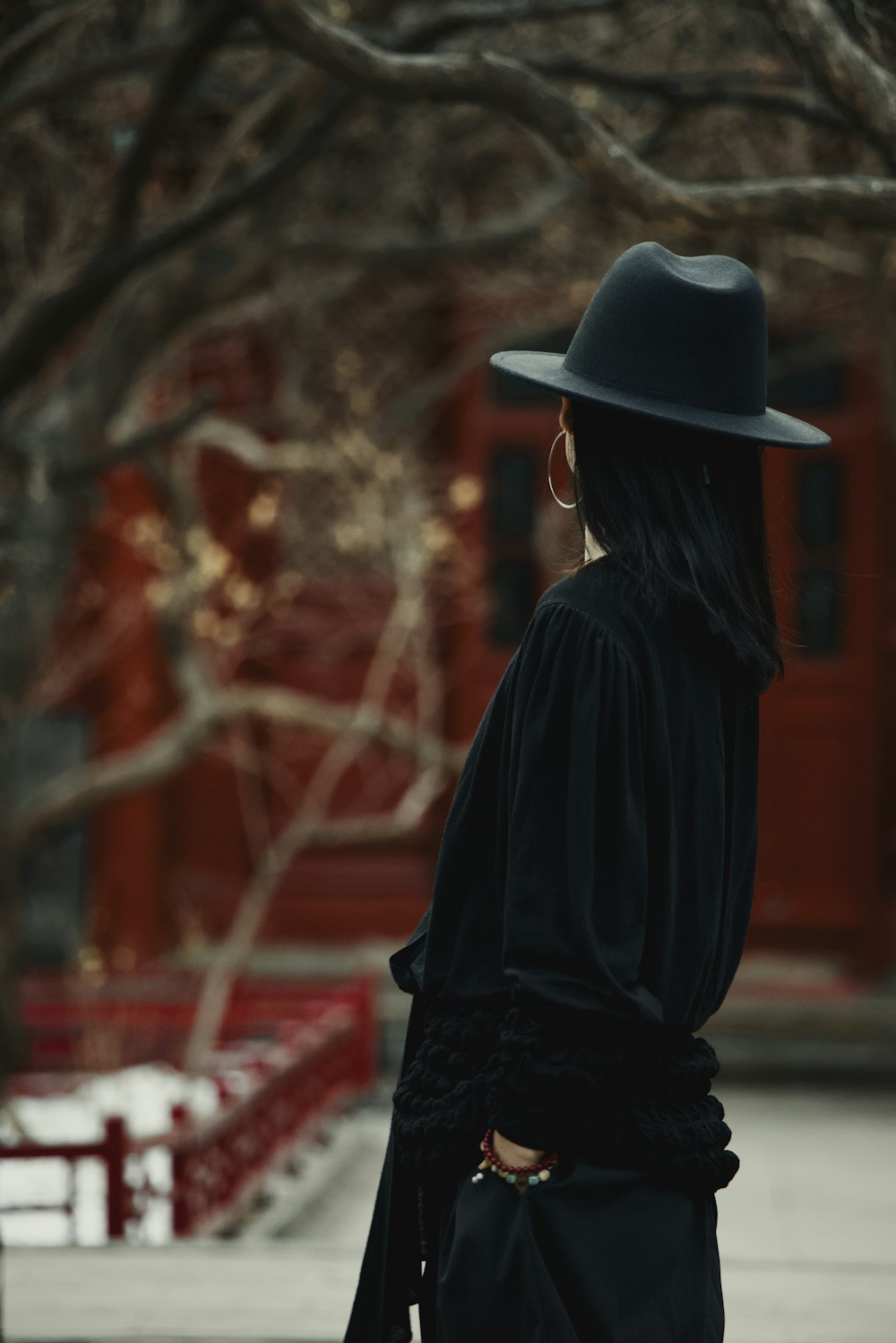 a woman wearing a black hat and a black dress