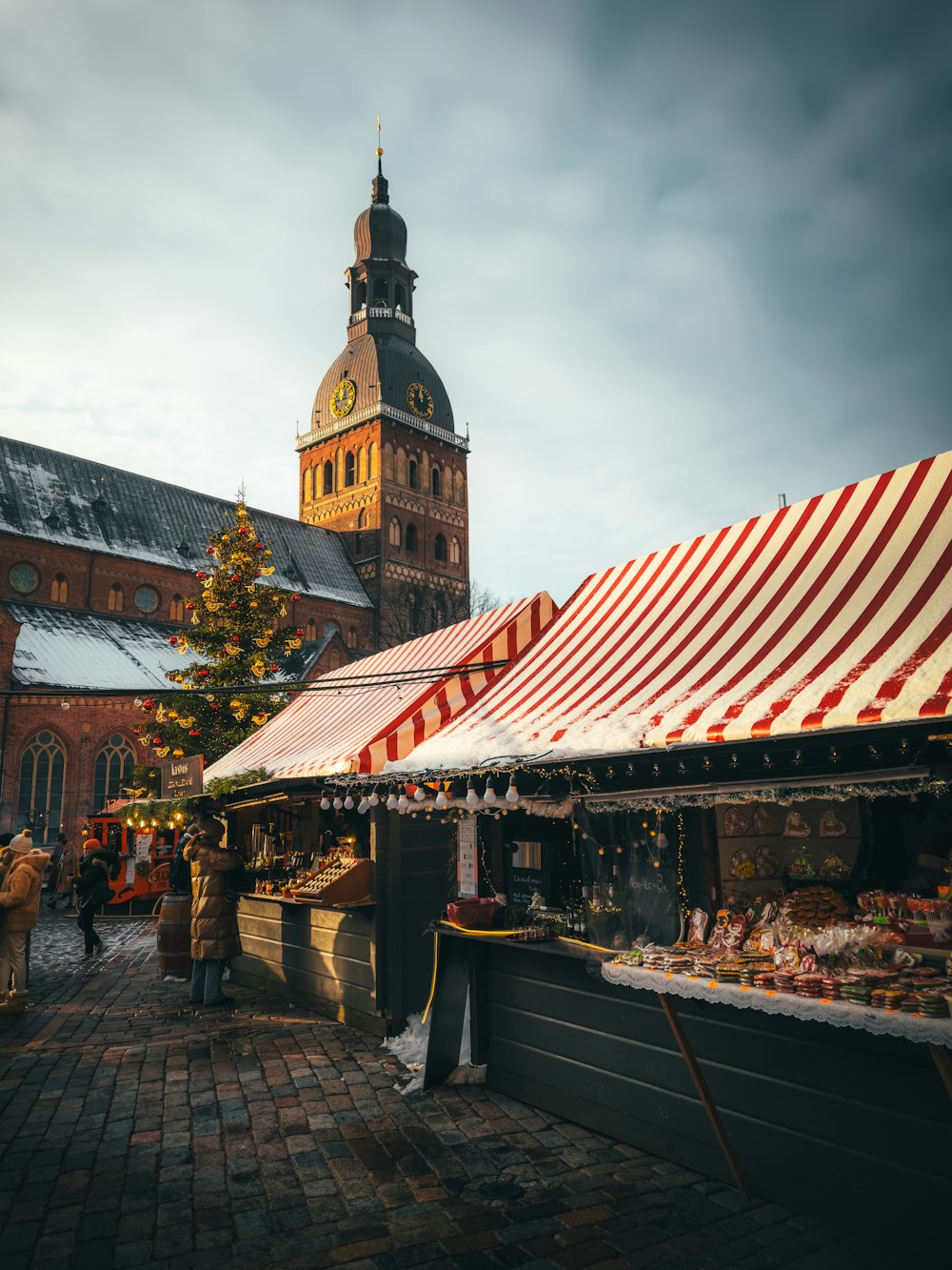 a market in front of a large building with a clock tower