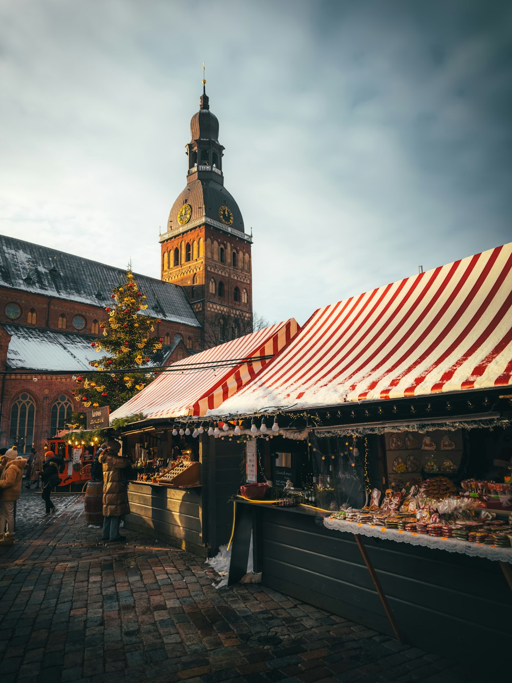 un mercato di fronte a un grande edificio con una torre dell'orologio