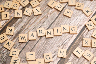 scrabble tiles spelling warning on a wooden surface