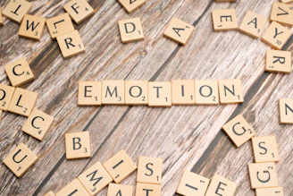 scrabble tiles spelling the word emotion on a wooden surface