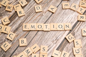 scrabble tiles spelling the word emotion on a wooden surface