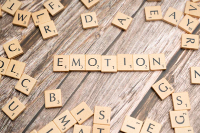scrabble tiles spelling the word emotion on a wooden surface