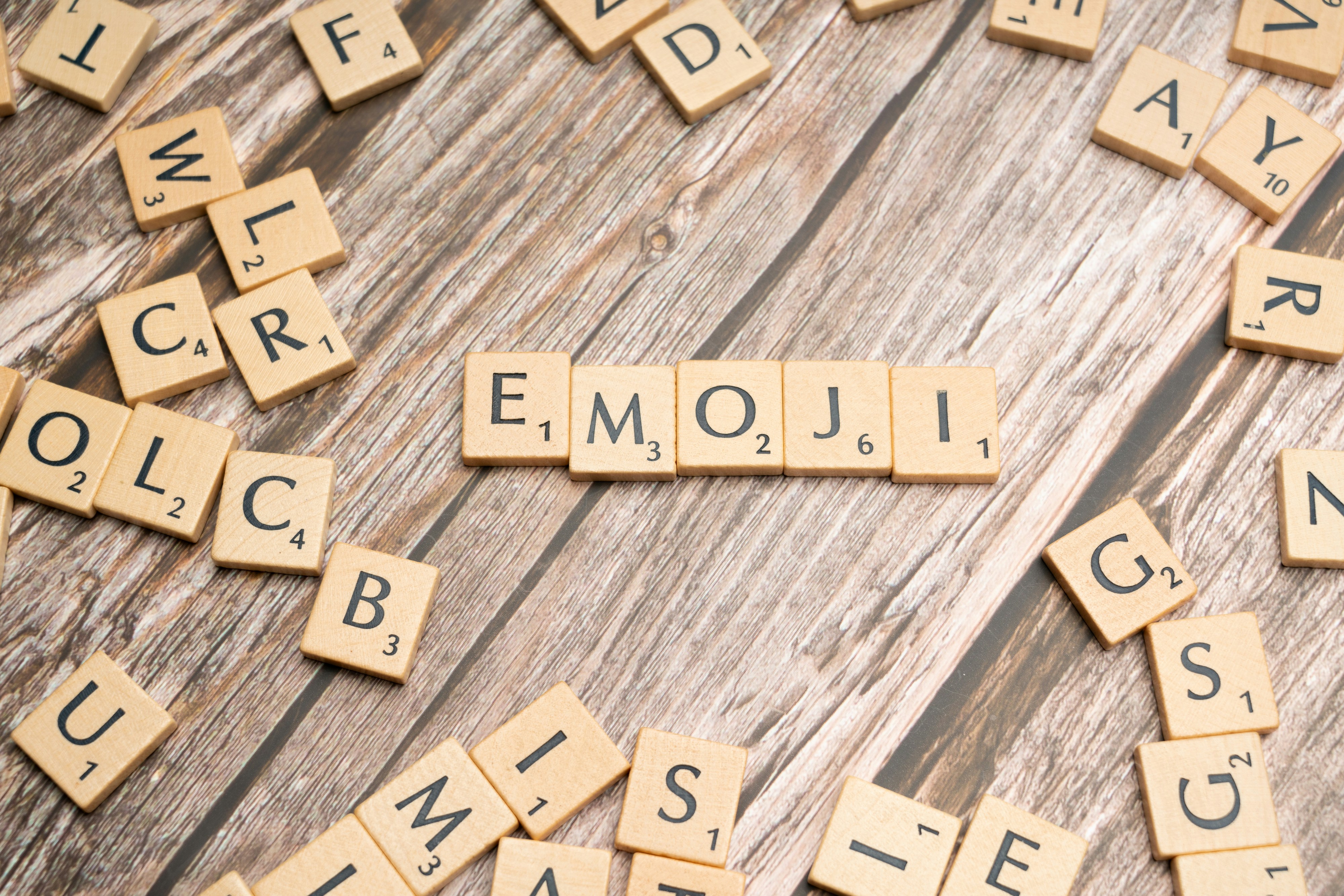 Scrabble tiles spelling the word emojii on a wooden surface - Free ...