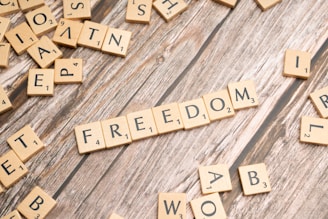scrabble tiles spelling out the word freedom