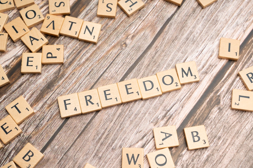 scrabble tiles spelling out the word freedom