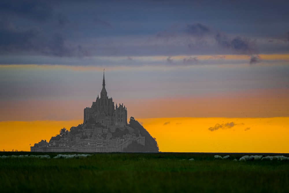 ein sehr hohes Gebäude, das mitten auf einem Feld sitzt