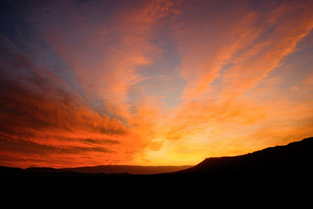 el sol se está poniendo sobre una cadena montañosa