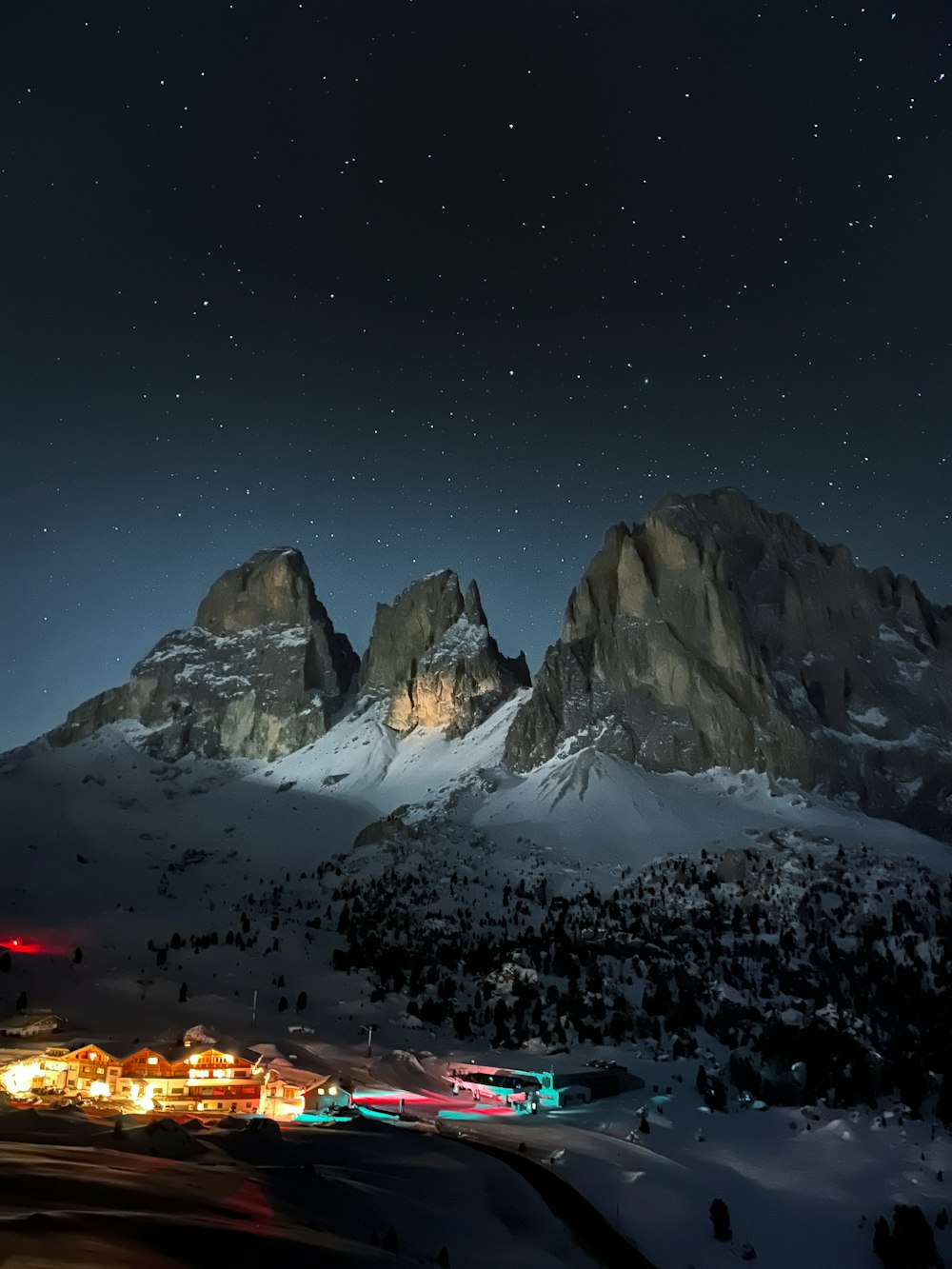 a snowy mountain range with a few lights on it