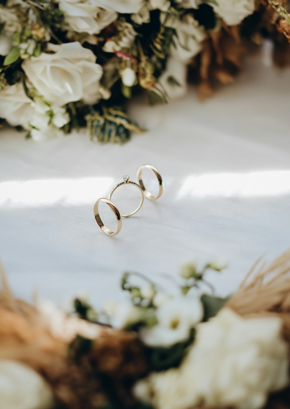 dois anéis sentados em cima de um buquê de flores