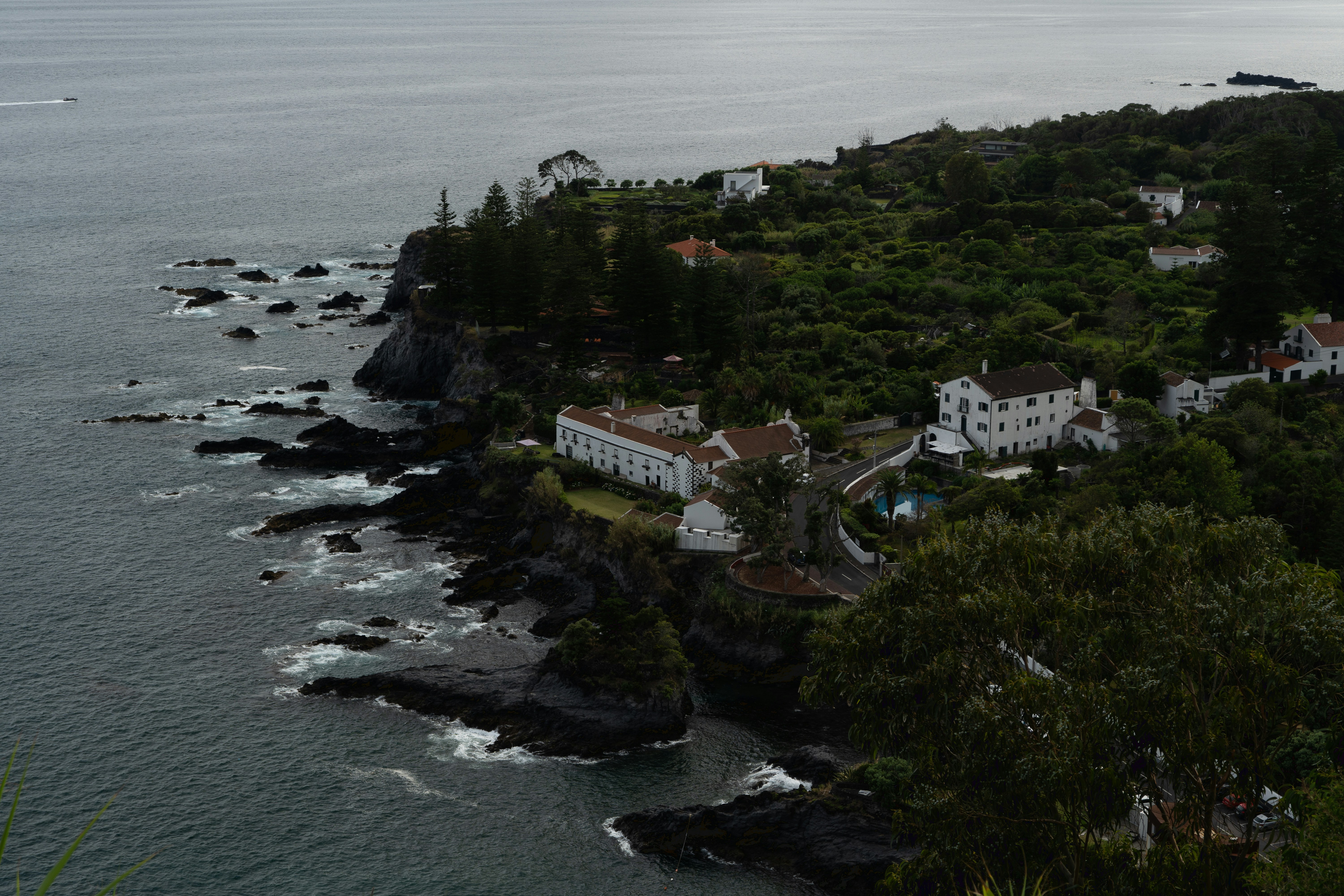 an aerial view of a house on a cliff near the ocean, View of the town Água de Pau belonging to the municipality of Lagoa, located on the Island of São Miguel, Autonomous Region of Azores.