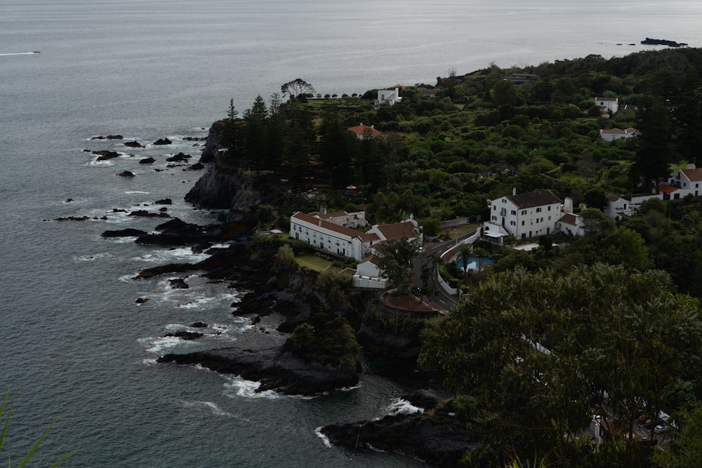 an aerial view of a house on a cliff near the ocean