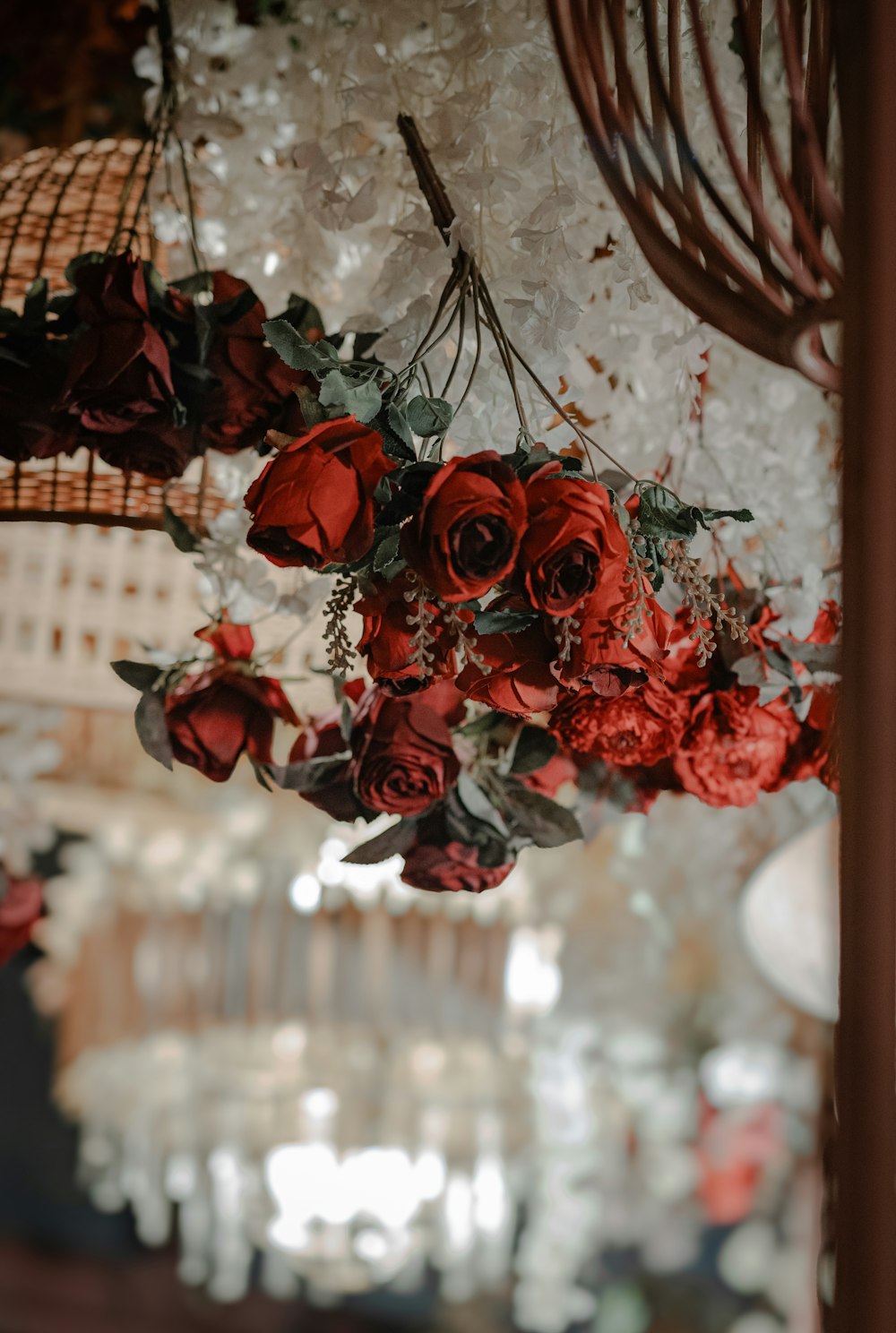 a bunch of red flowers hanging from a chandelier