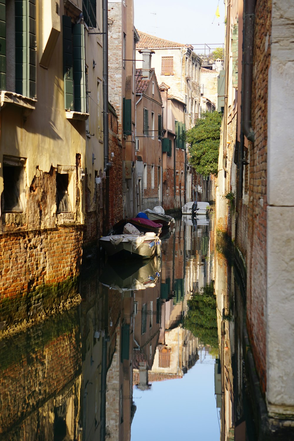 a narrow canal with a boat in the middle of it