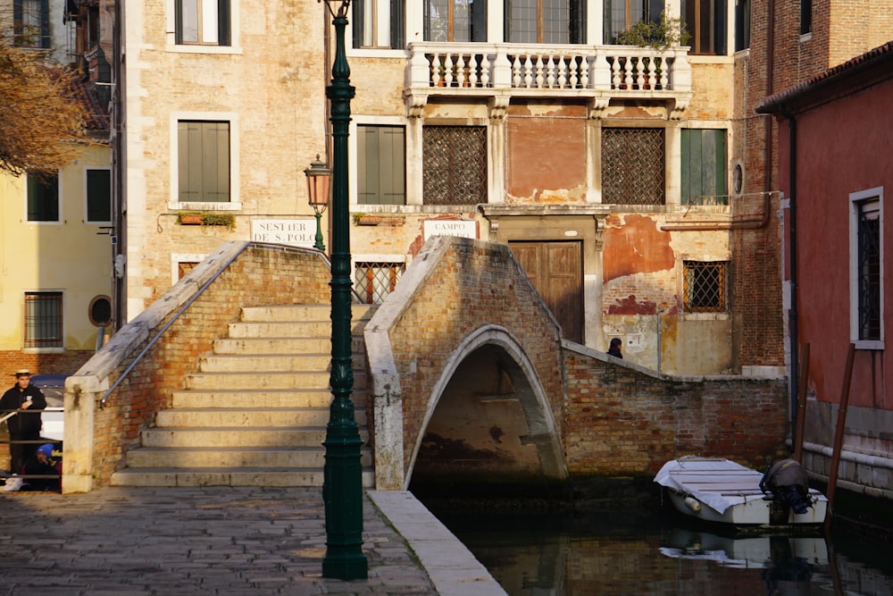 a bridge over a canal with a boat in the water