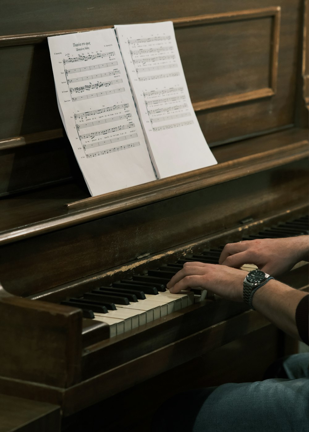 a man sitting at a piano with sheet music on it