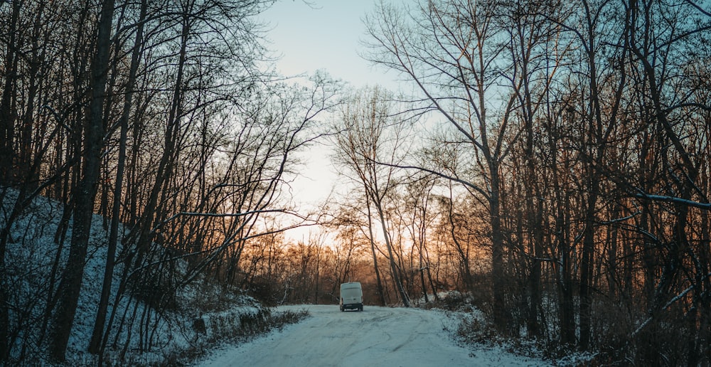 a truck driving down a snow covered road