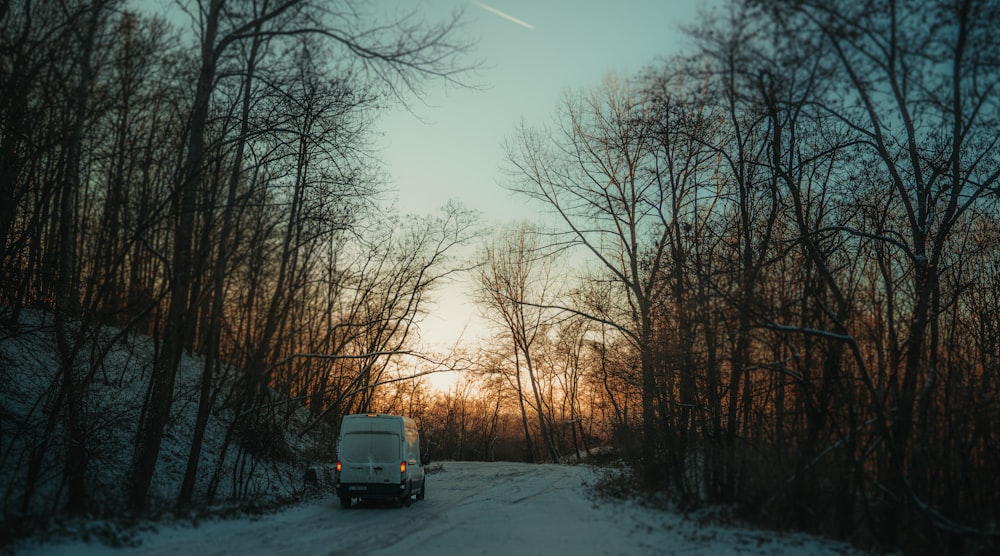 a truck driving down a snow covered road