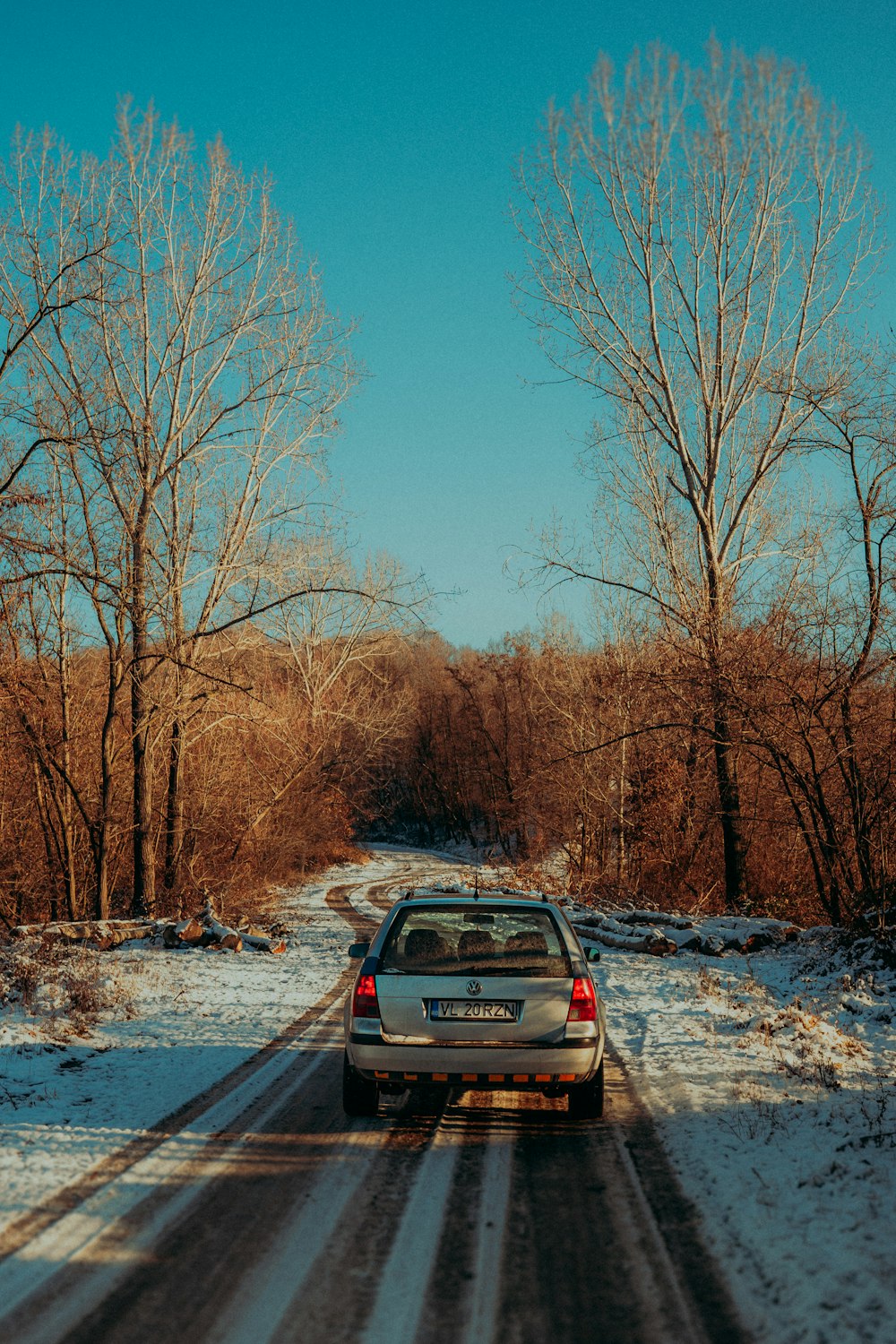 a car driving down a snow covered road