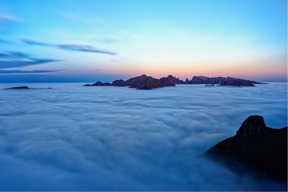 a view of a sea of clouds with a mountain in the distance