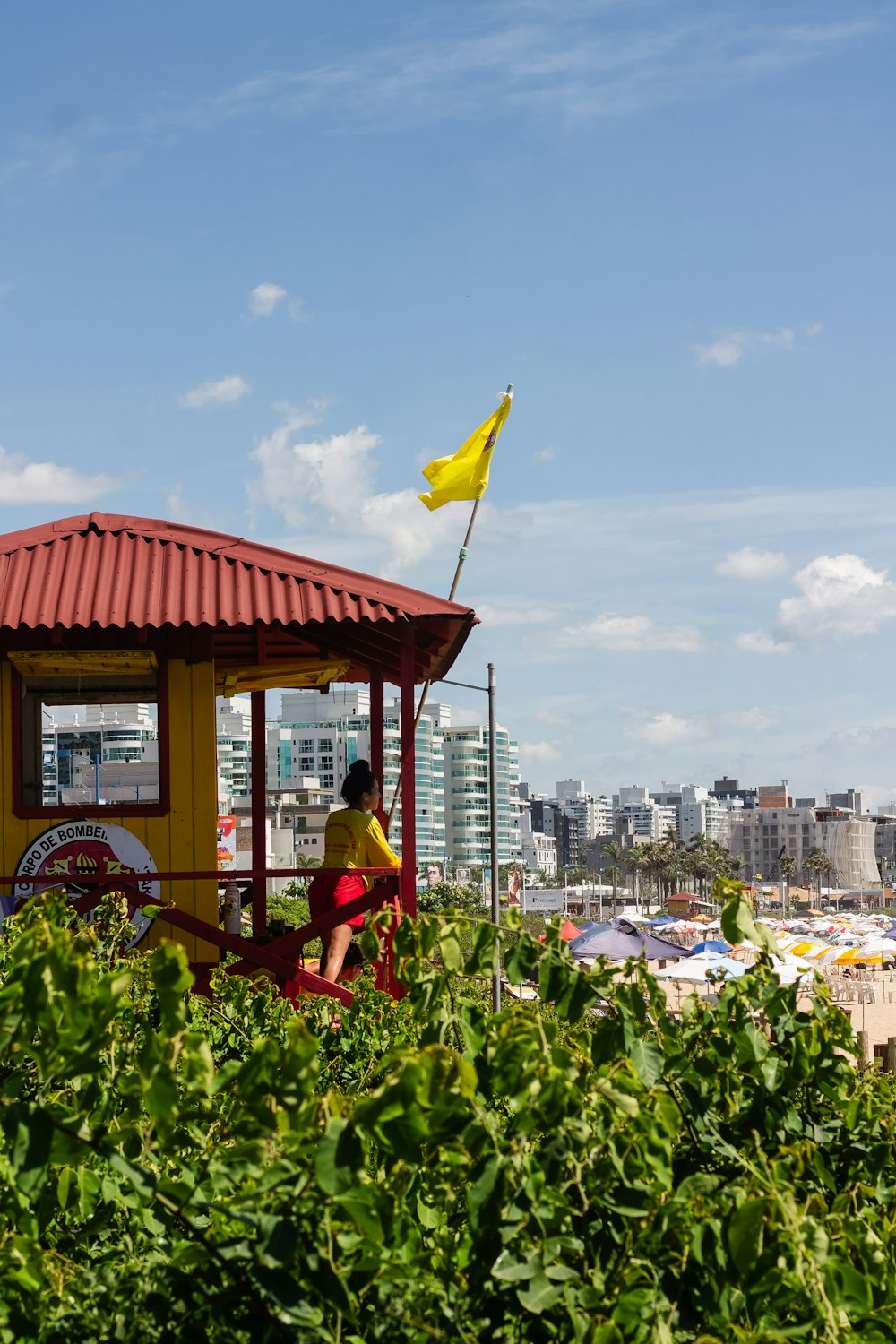 a man sitting on a bench next to a yellow flag