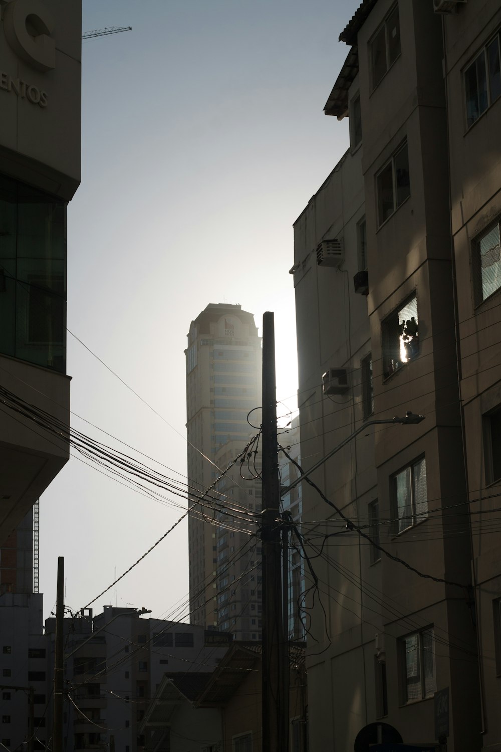 the sun is shining behind a tall building