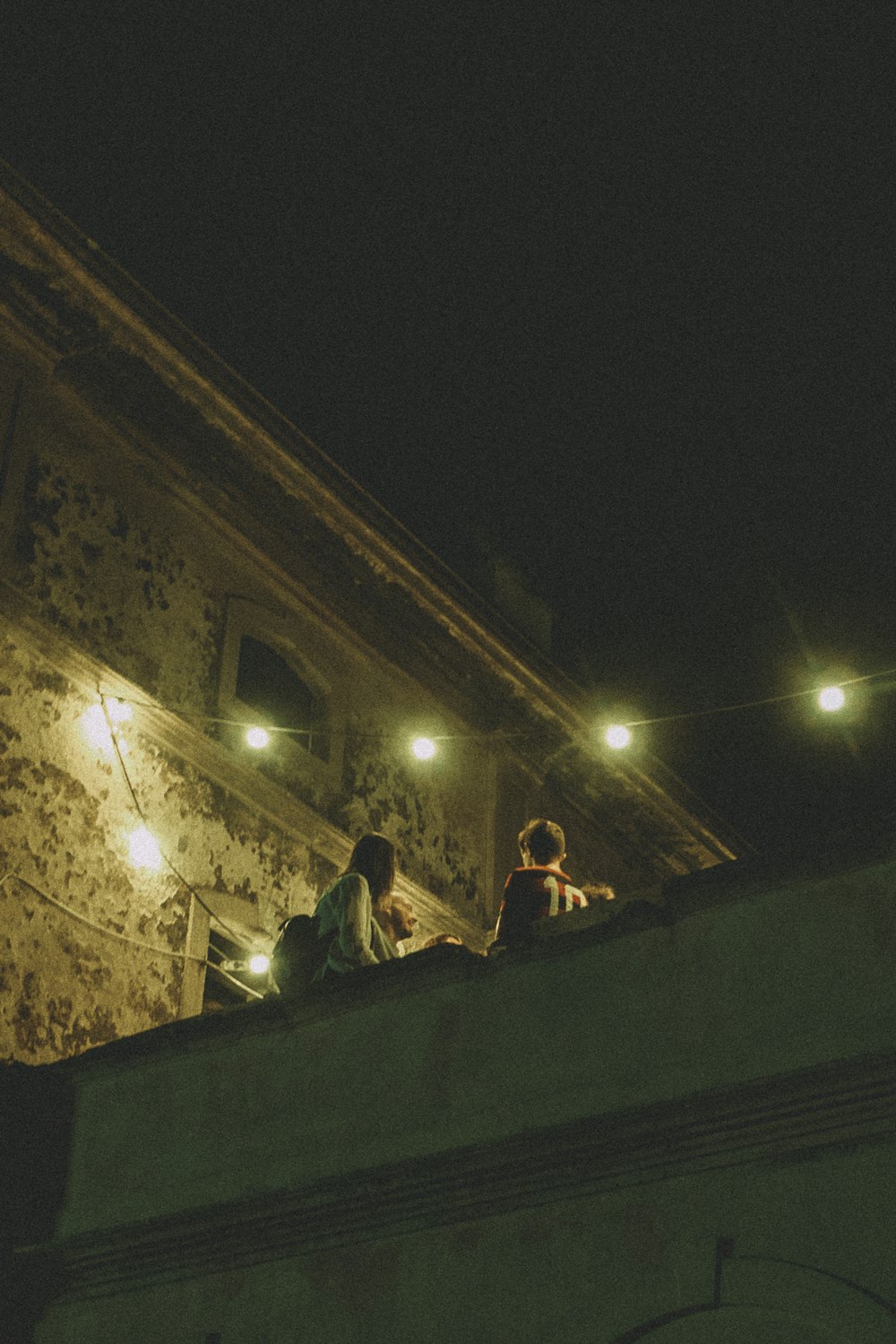 a couple of people sitting on top of a roof