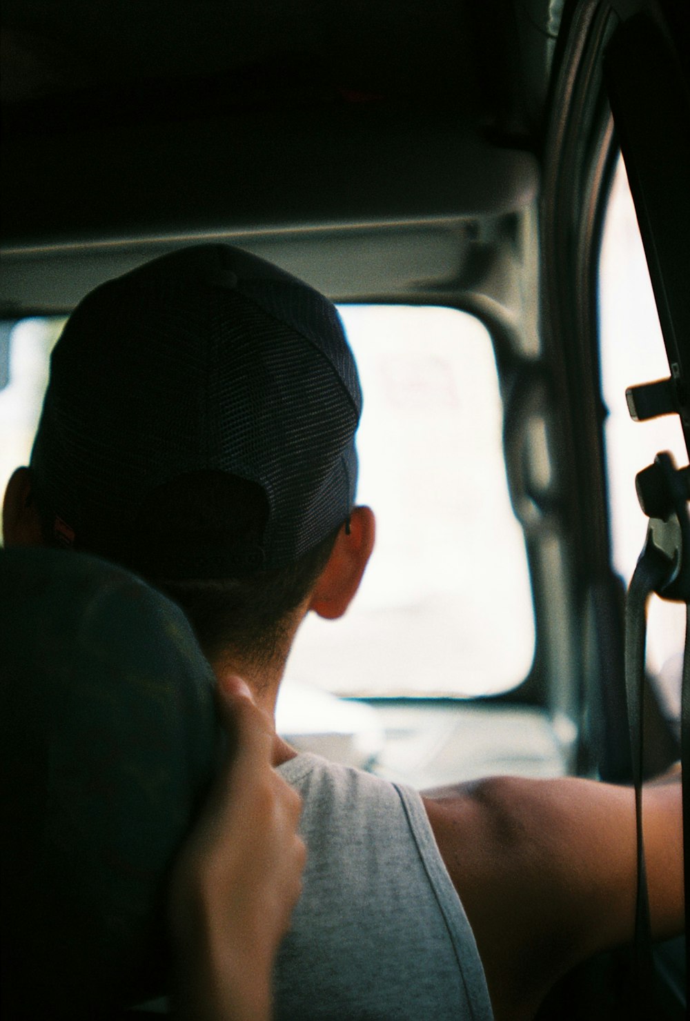 a man driving a car with a hat on