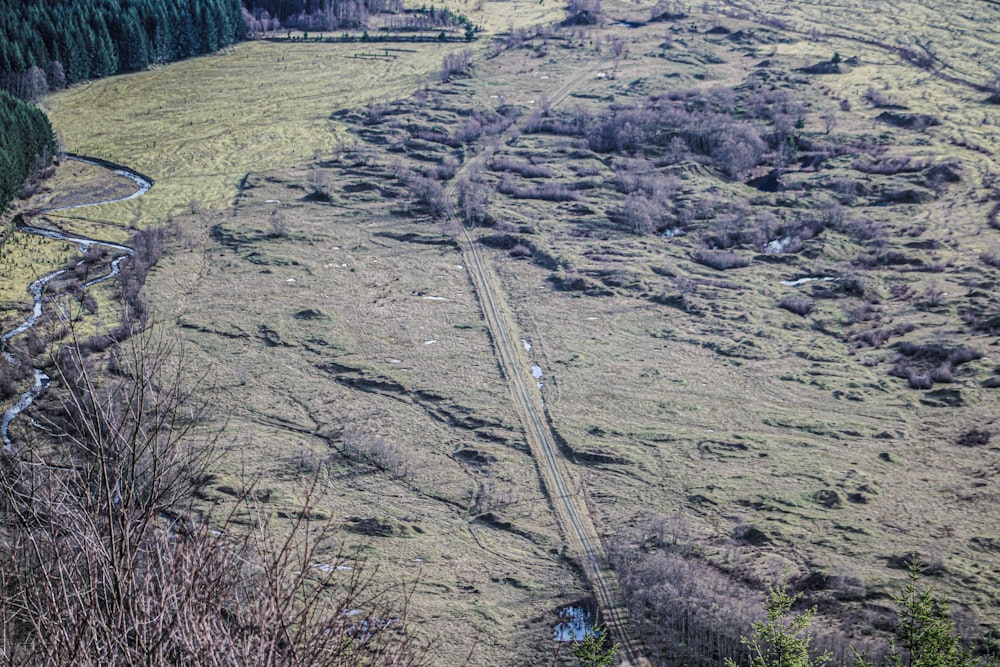 an aerial view of a train track in the middle of a field