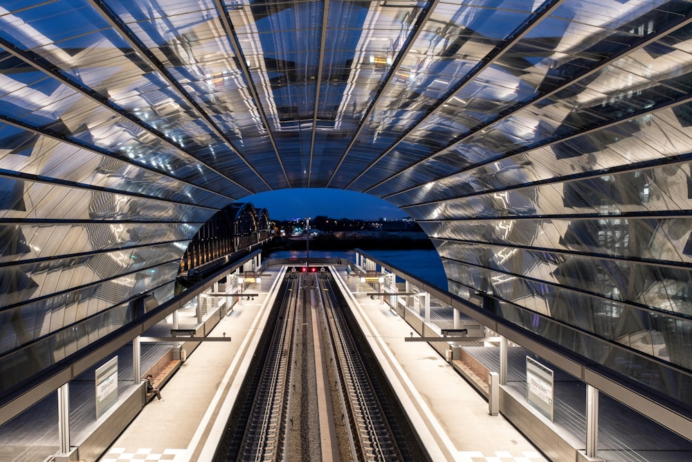 a train traveling through a train station under a blue sky