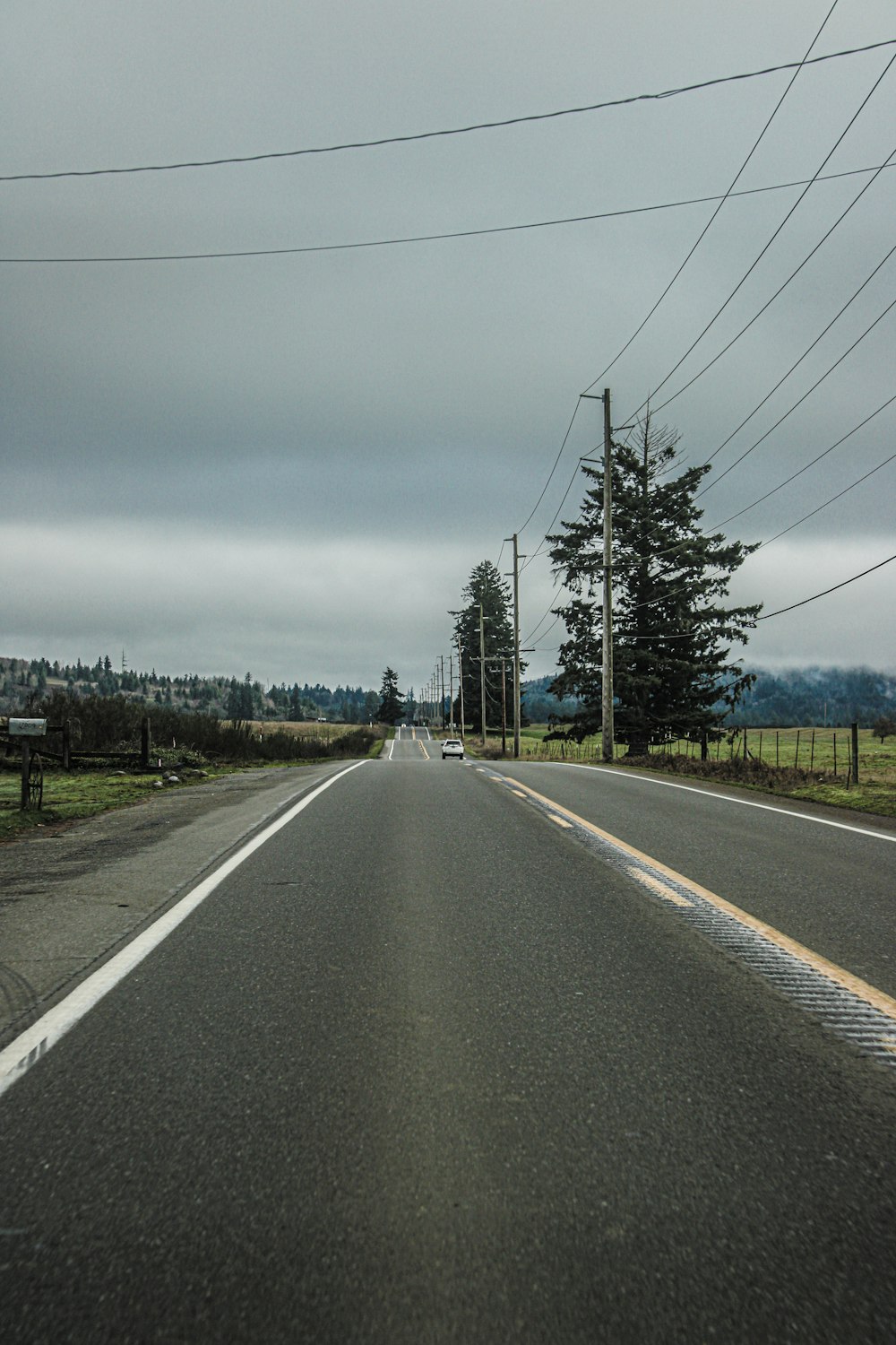 an empty road with power lines above it