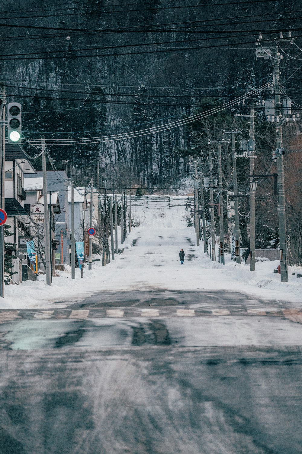 a snowy street with a stop light on it