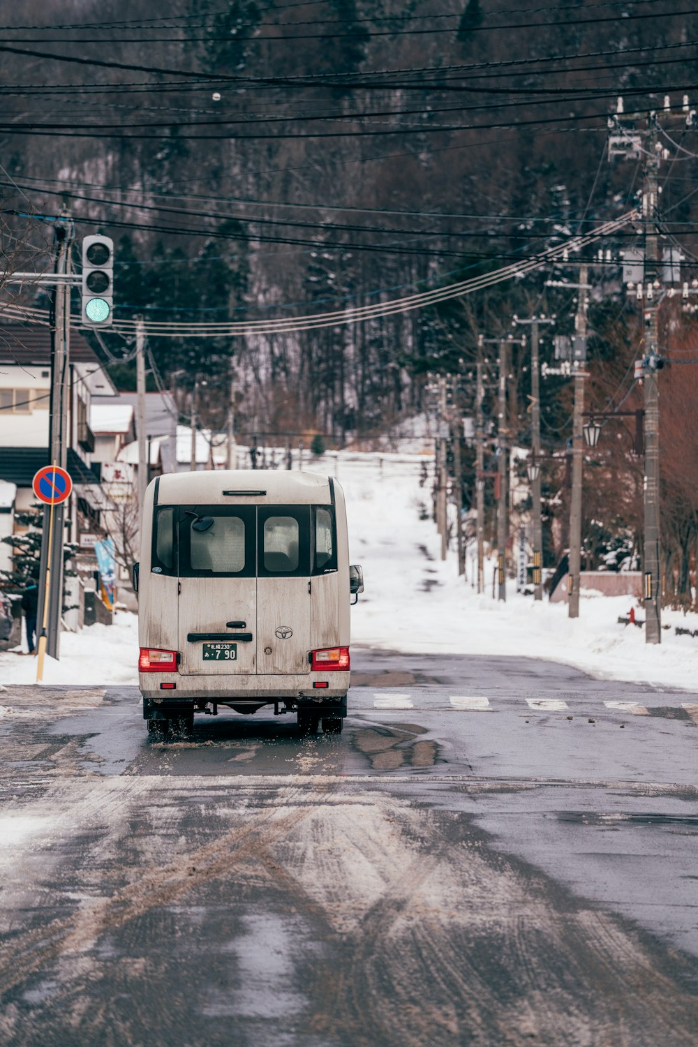 a small van driving down a snow covered road