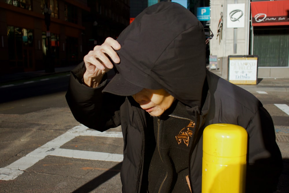 a man in a hooded jacket is walking down the street