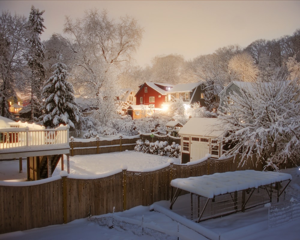 a snow covered yard with a house and trees