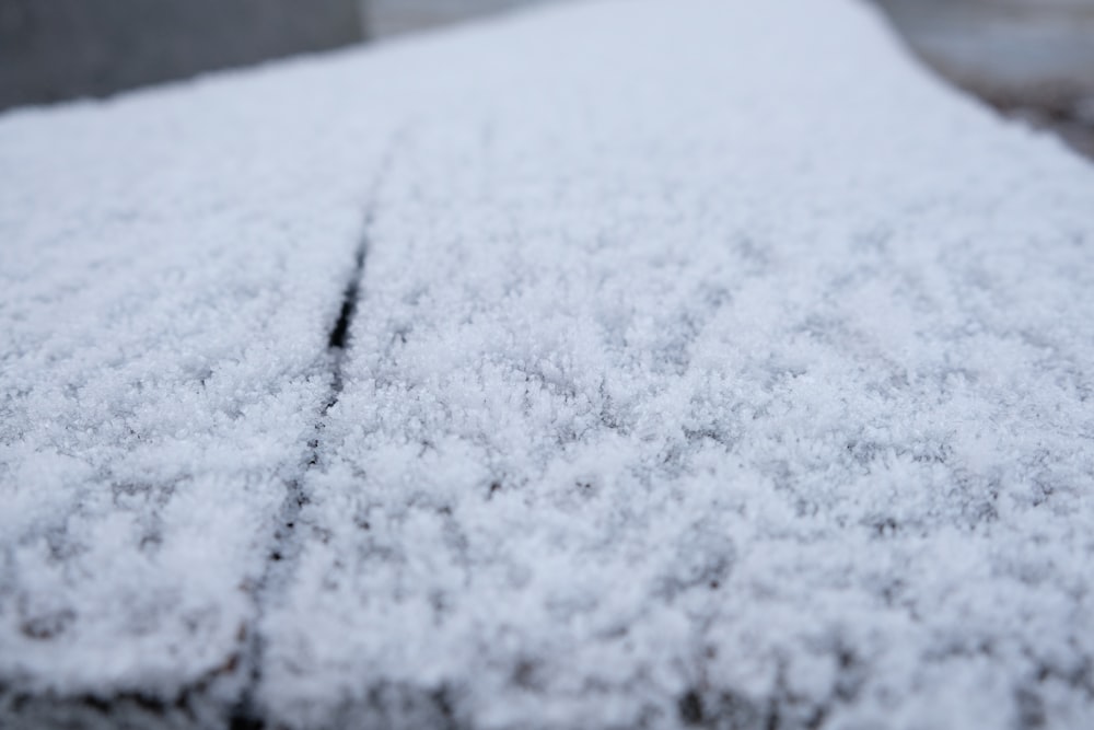 a close up of snow on a wooden surface