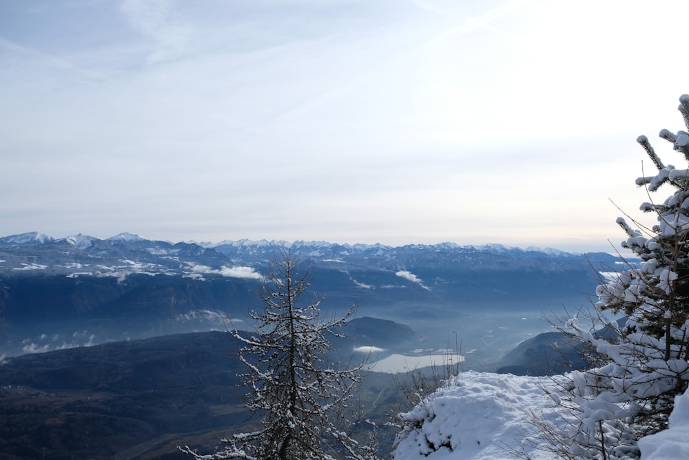 a view of a snowy mountain with trees and mountains in the background