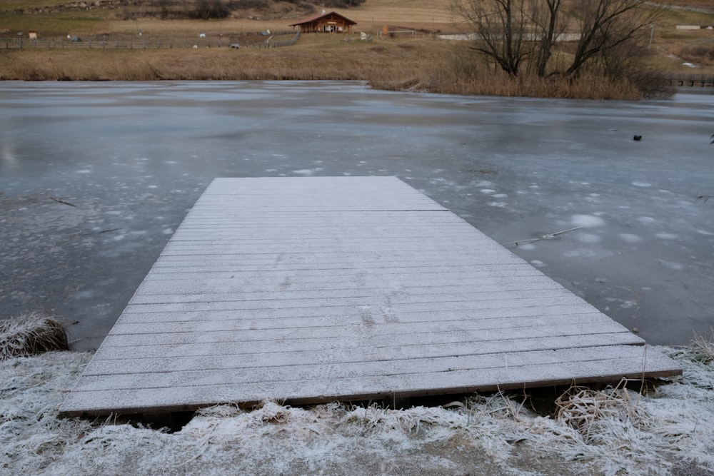 a wooden dock sitting on top of a frozen lake