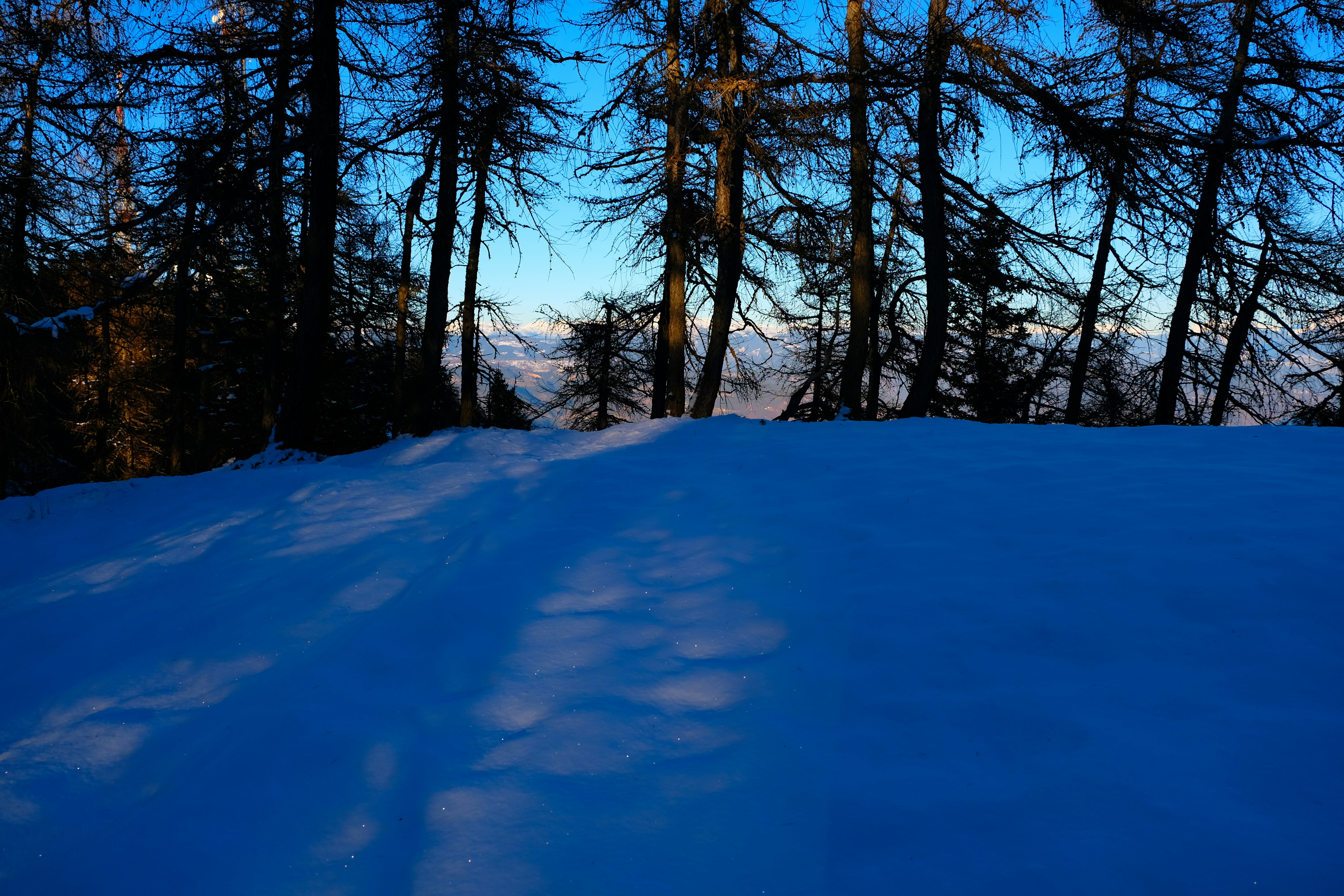a person riding a snowboard down a snow covered slope