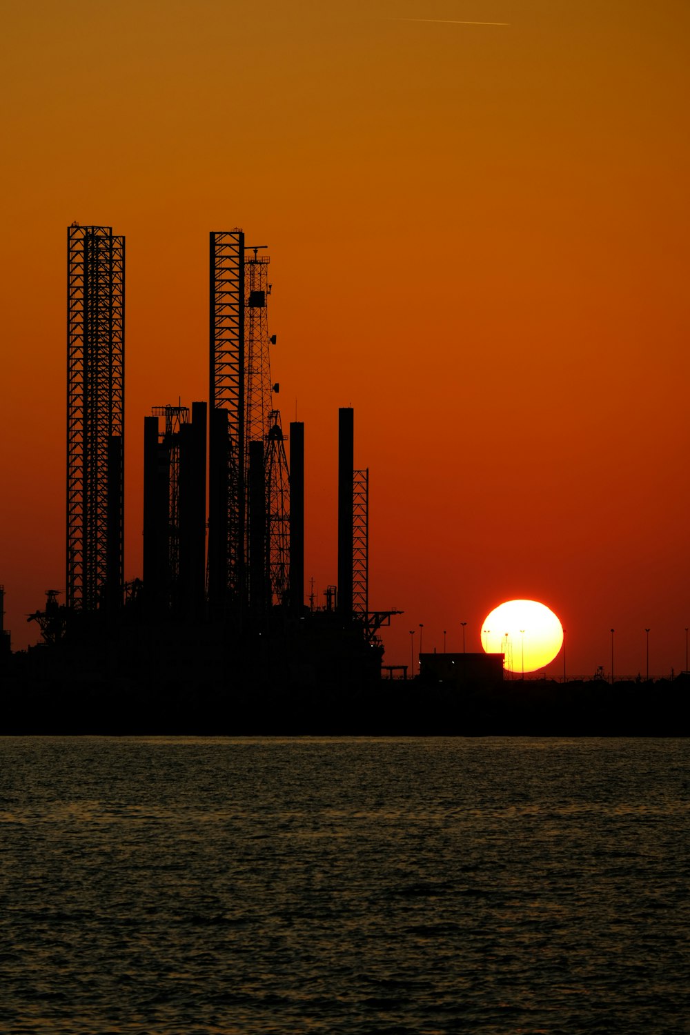 the sun is setting over a large oil refinery