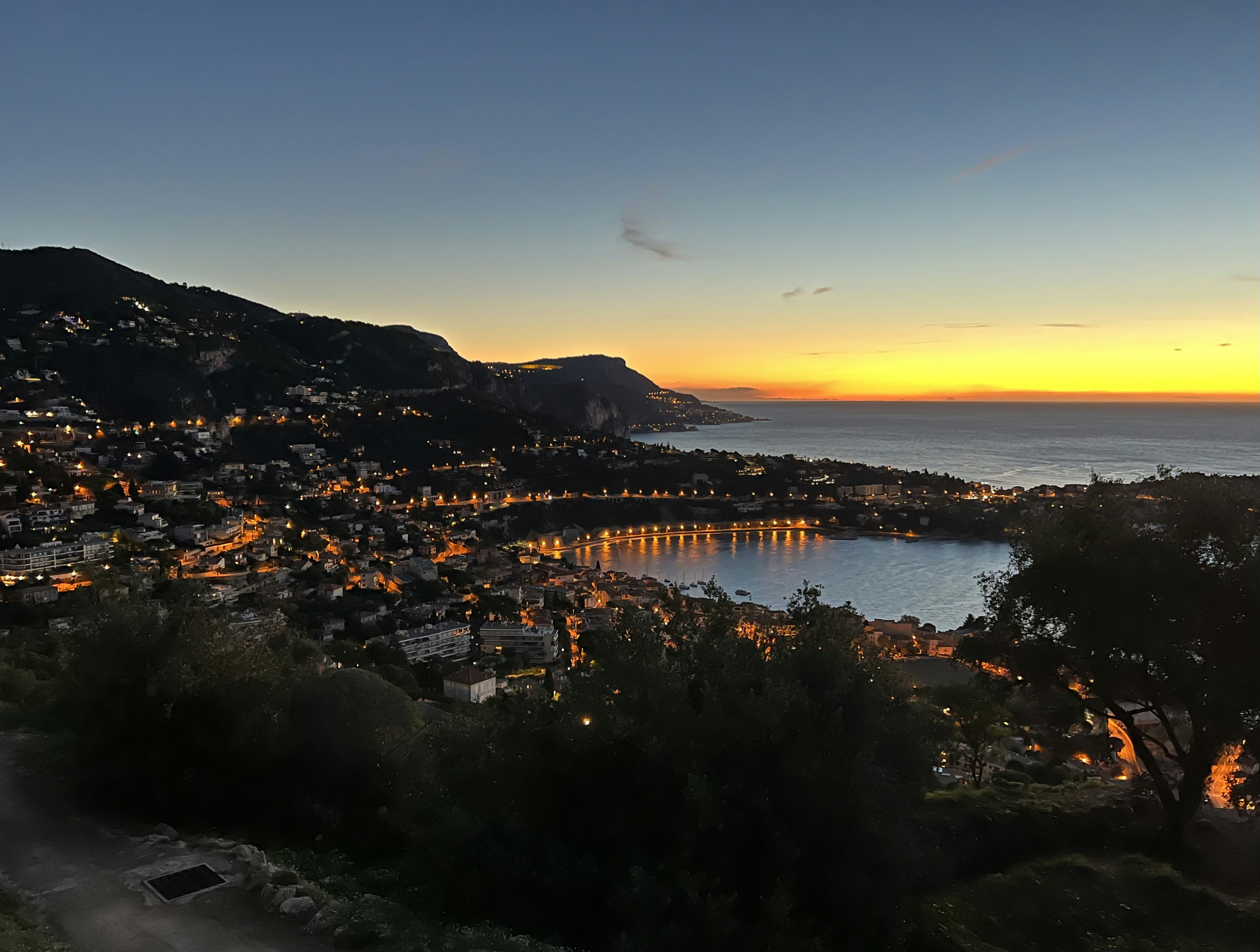 a view of a city at night from a hill