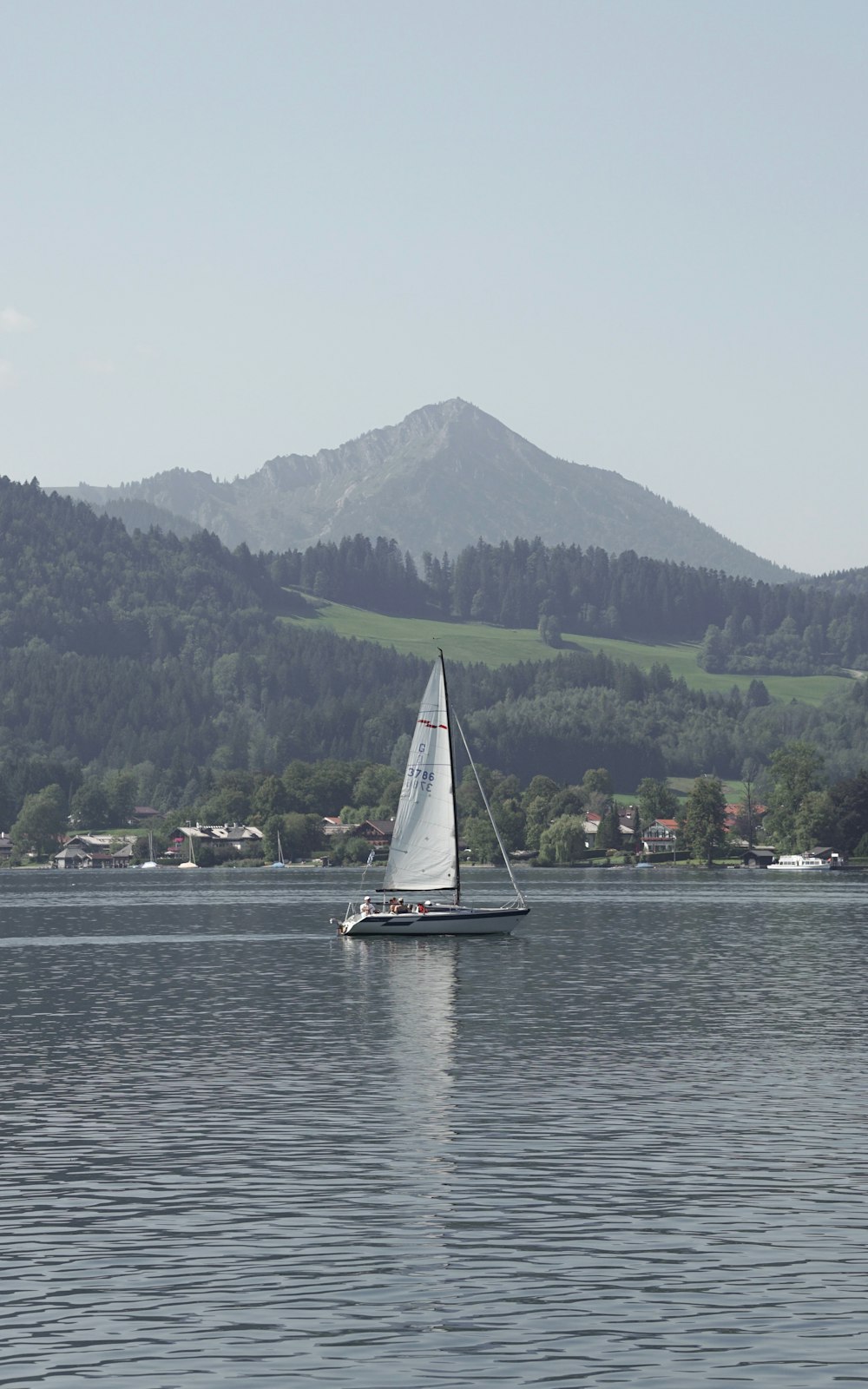 un voilier sur un lac avec une montagne en arrière-plan