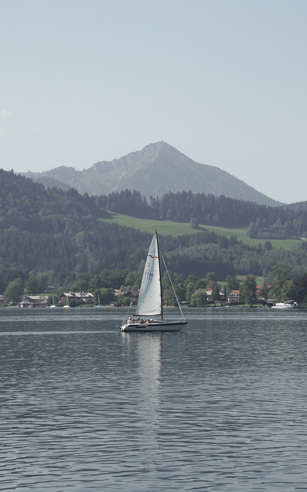 un velero en un lago con una montaña al fondo