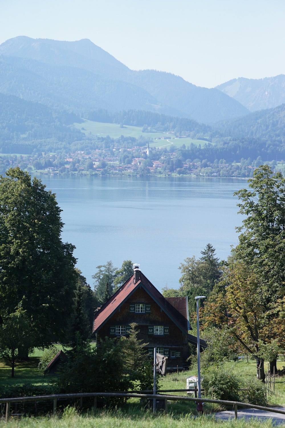 a house on a hill with a lake in the background
