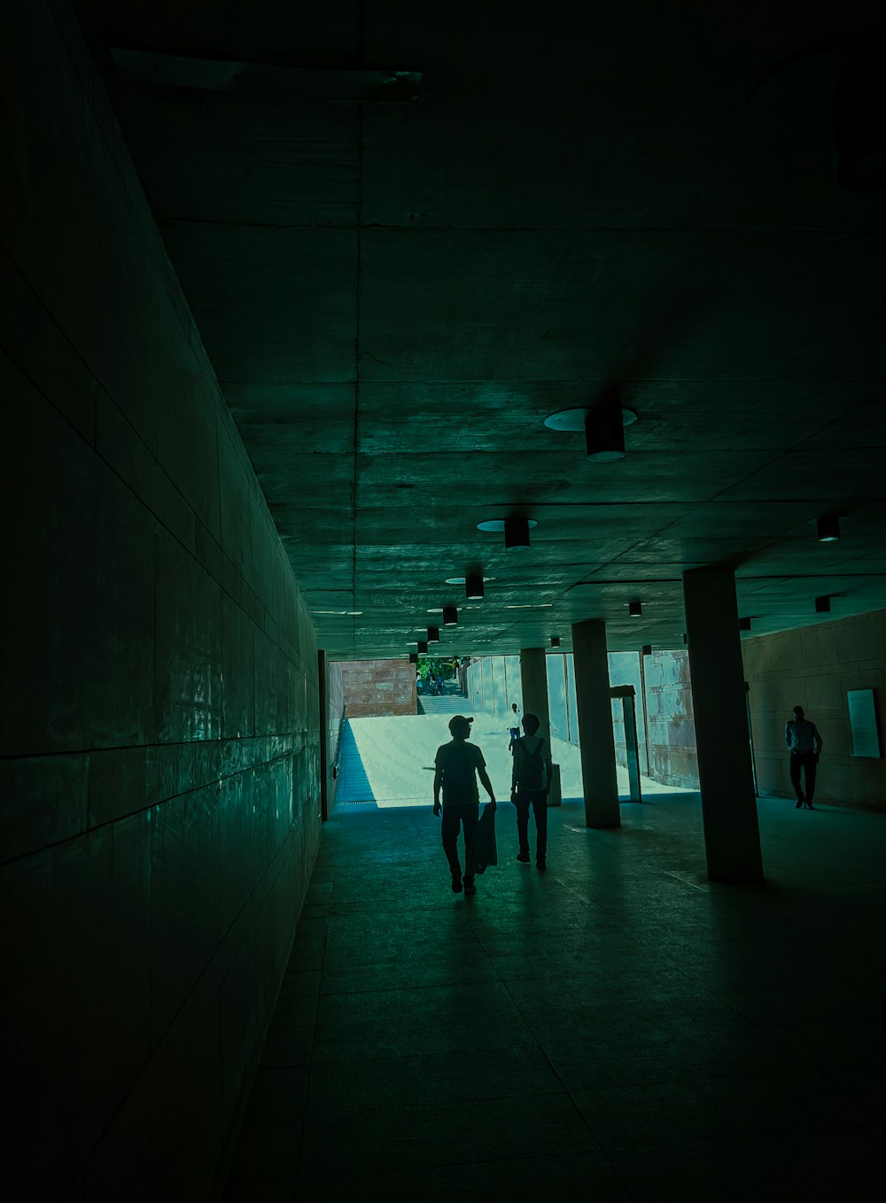 a group of people walking down a dark hallway