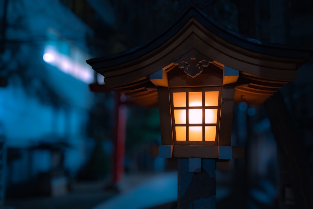 a lit up lantern on a pole in the dark