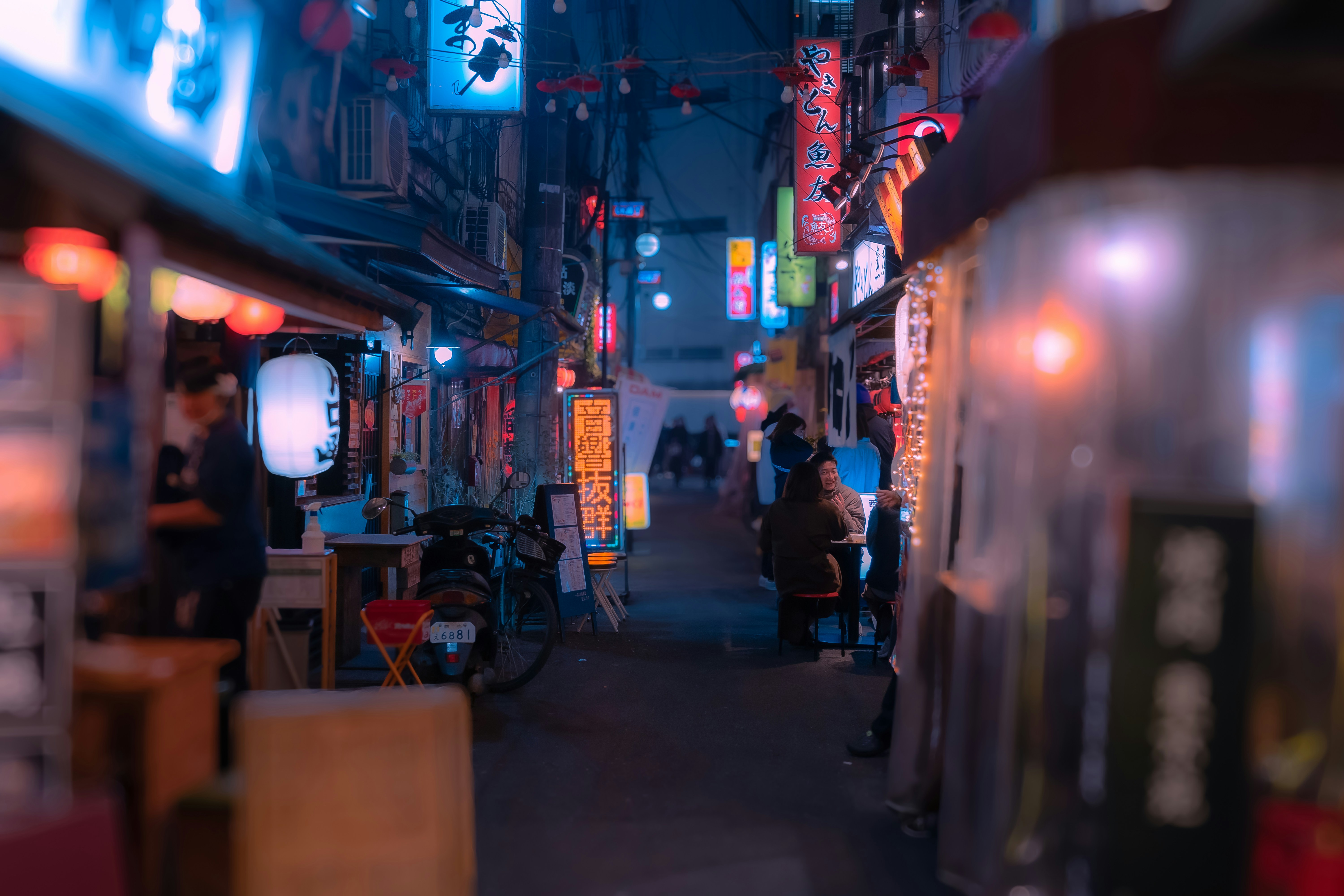 a narrow alley way with people walking down it
