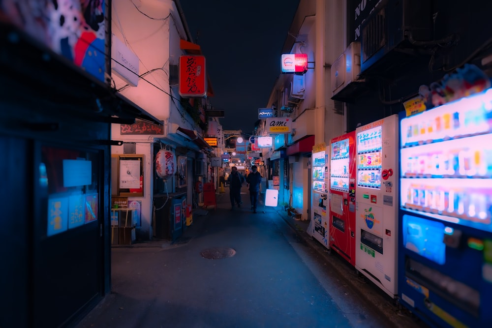 a city street at night with people walking down it